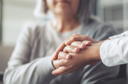 Mantelzorger houdt handen vast moeder.